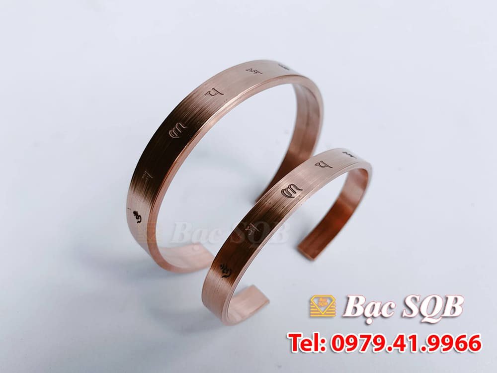 Bàn tay đeo vòng đồng trên nền tối