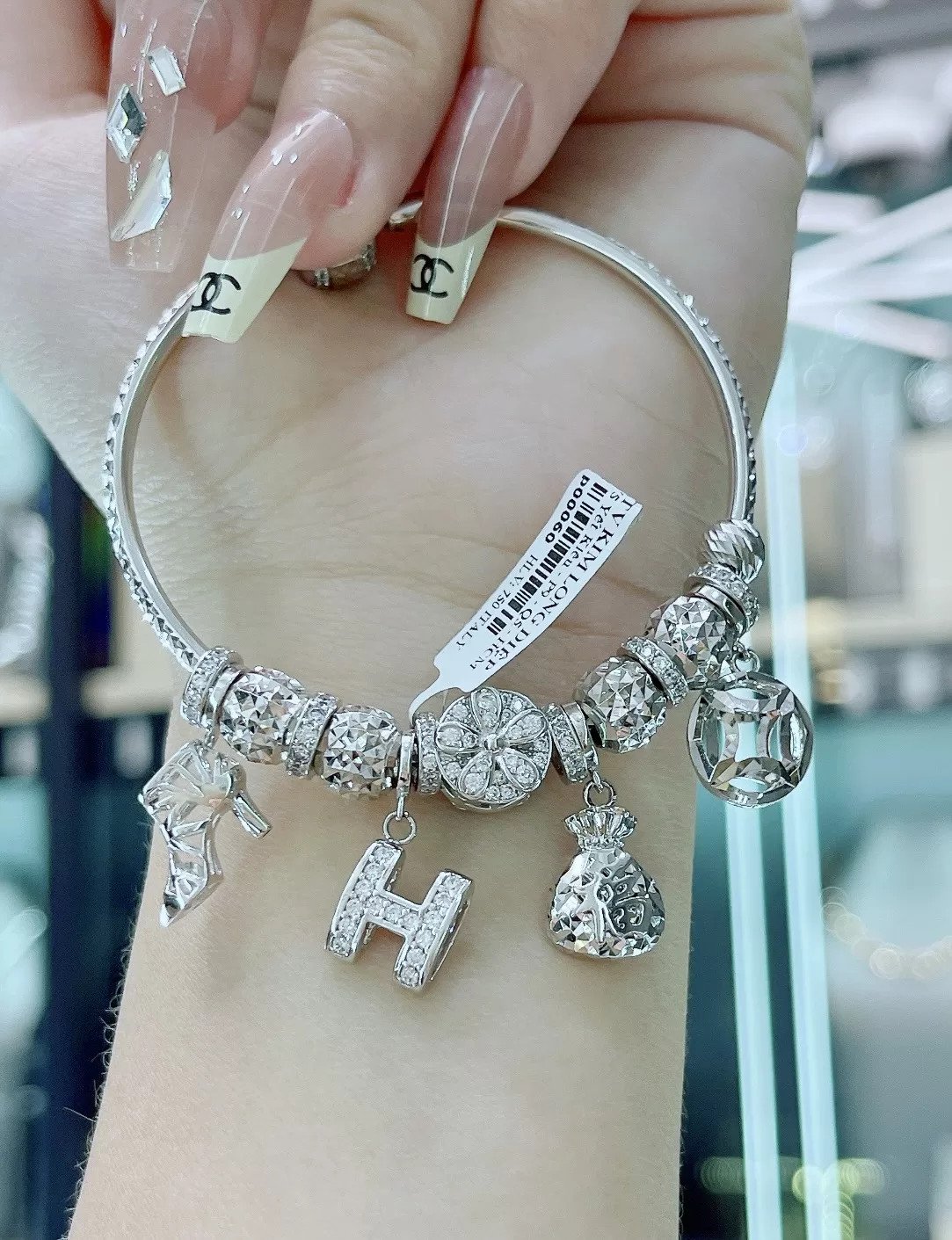 Các charm độc đáo như kim tiền, chữ H và túi tiền trên vòng tay Pandora vàng trắng