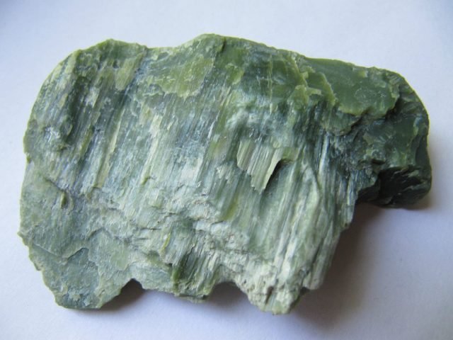 Hình ảnh cận cảnh một viên đá Serpentine thô với màu xanh lá đặc trưng, thể hiện những vân đá tự nhiên tinh xảo.