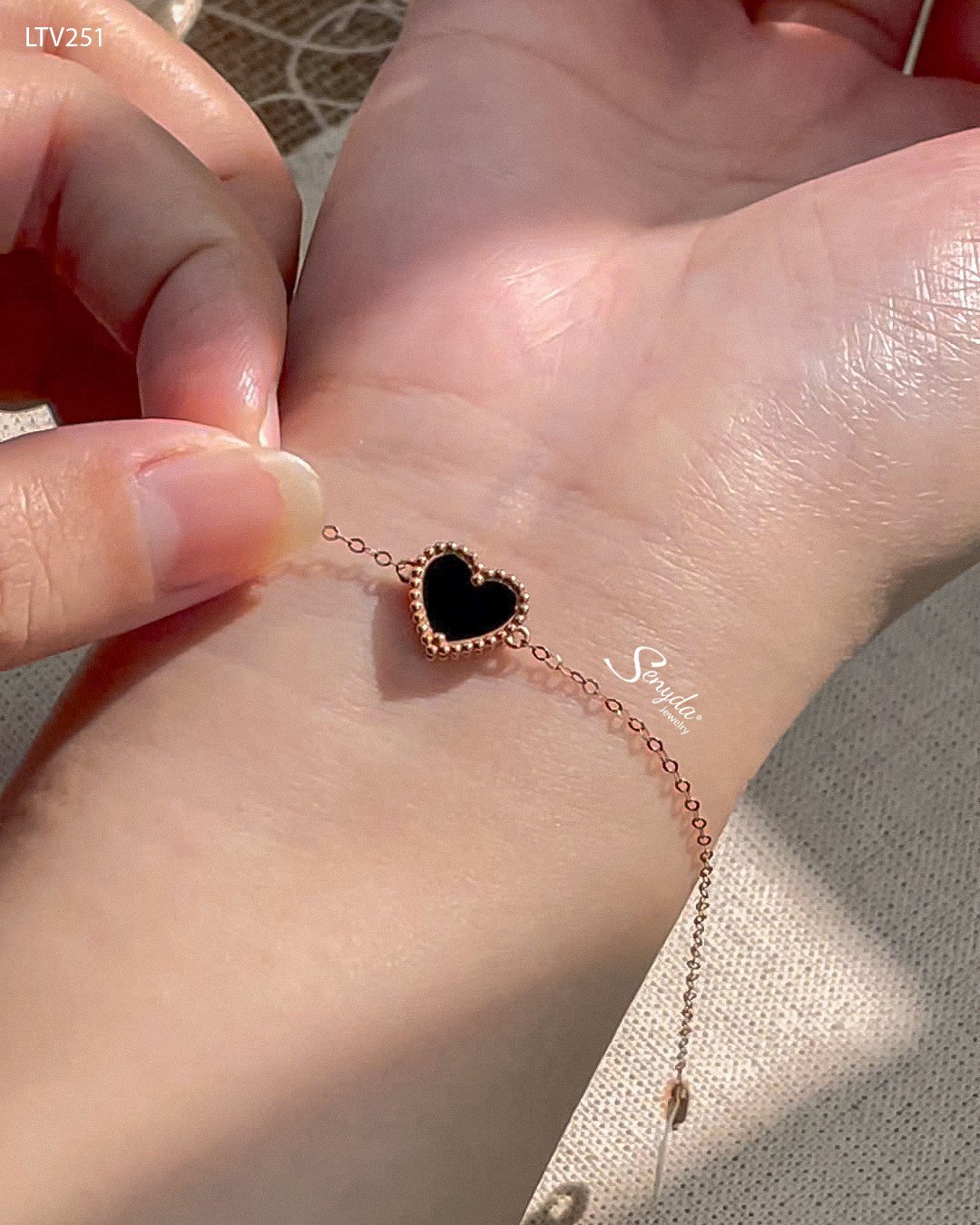 Lắc tay vàng 18K mặt trái tim đá đen huyền bí, một lựa chọn trang sức cá tính cho nữ.