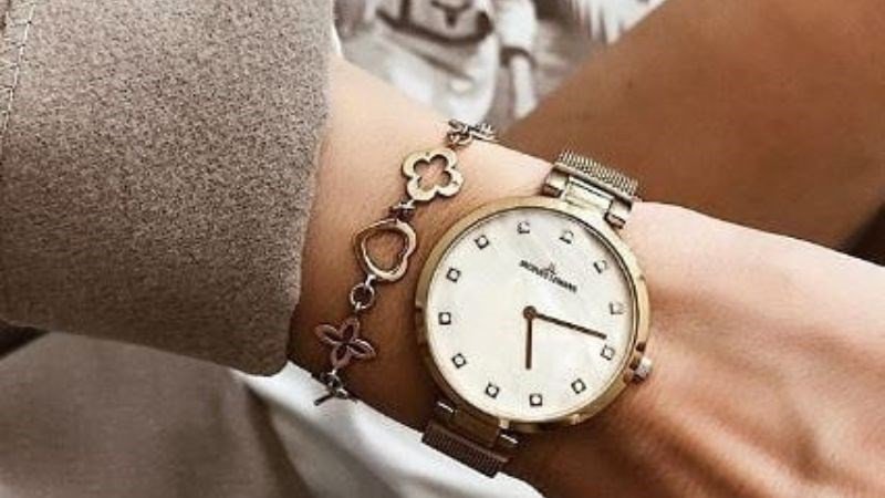 Người phụ nữ đeo đồng hồ và vòng tay nữ cùng một cổ tay, tạo điểm nhấn cá nhân độc đáo và thời trang