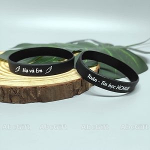Vòng tay lưu niệm màu xanh dương in chữ trắng, biểu tượng của kỷ niệm và sự kiện đặc biệt.
