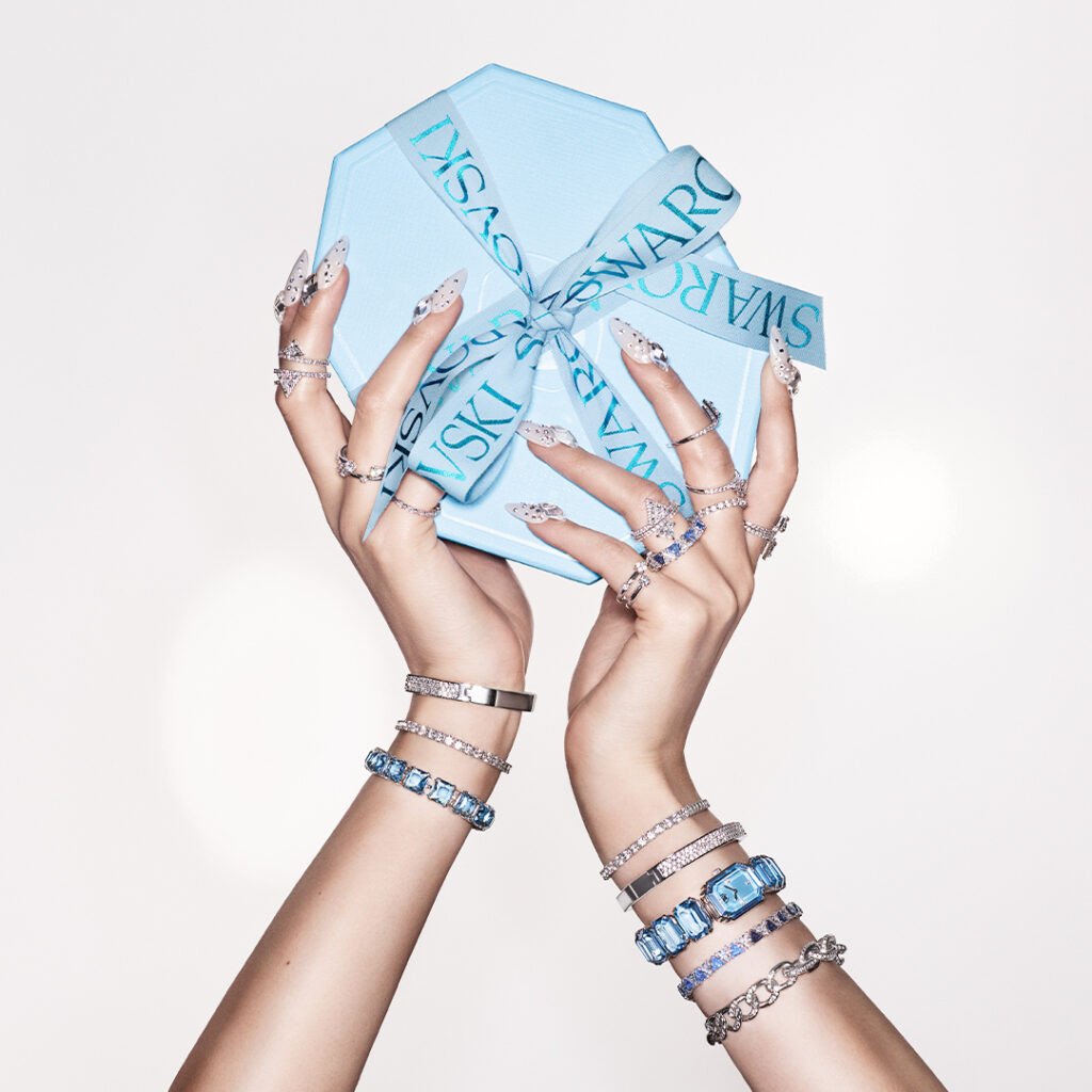 Bàn tay người phụ nữ đeo nhiều mẫu vòng tay Swarovski với thiết kế tinh tế