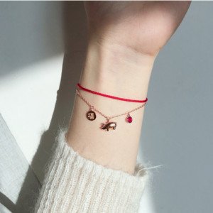 Chiếc vòng tay màu đỏ được thiết kế tinh xảo, có thêm charm nhỏ để tăng cường ý nghĩa may mắn.