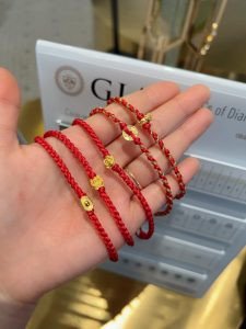 Dây chỉ đỏ làm vòng tay với các chi tiết charm vàng và hạt đậu tằm
