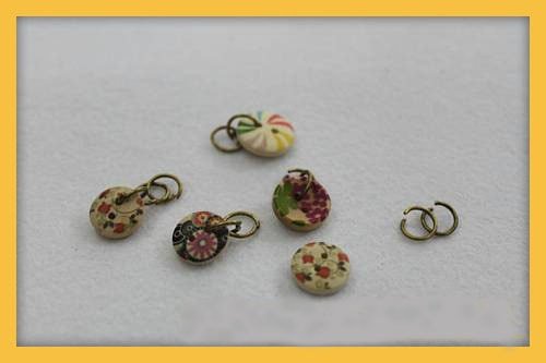 Gắn các nút áo vào khoen tròn, chuẩn bị móc vào dây xích để tạo vòng tay cá tính.