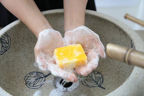 Hình ảnh một người đang dùng xà phòng để thoa lên cổ tay, minh họa mẹo đeo vòng tay dễ dàng hơn