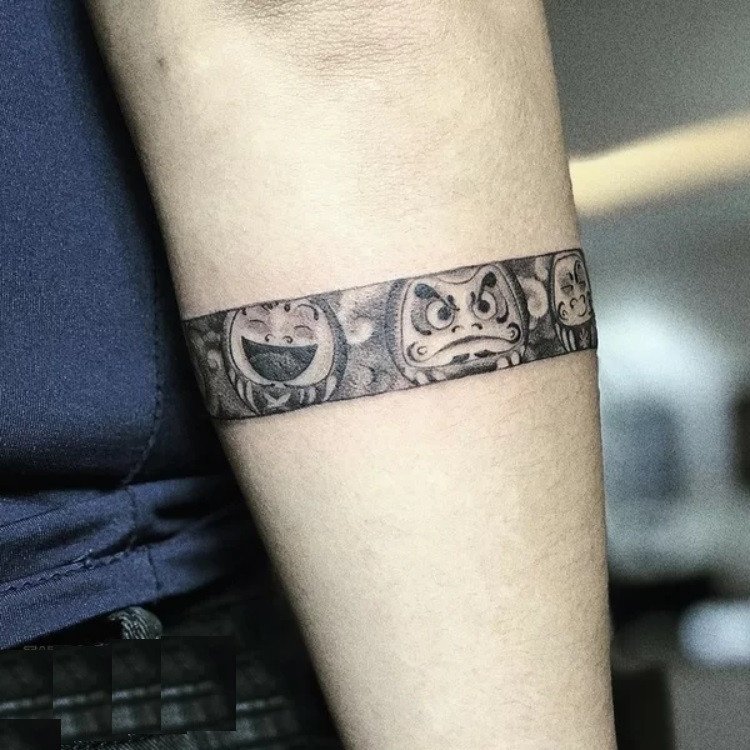 Hình xăm vòng tay nhật cổ đơn giản kết hợp búp bê Daruma