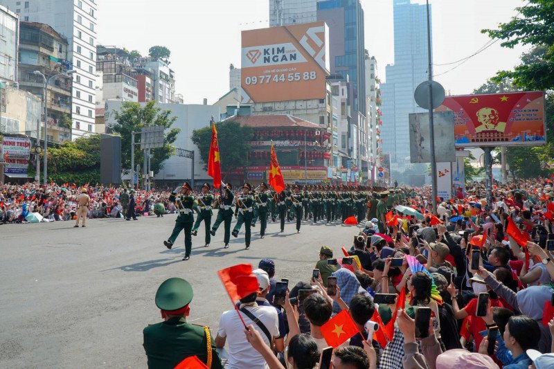 Khối diễu binh hùng tráng đi giữa vòng tay nhân dân với rừng cờ hoa chào đón.