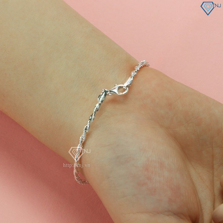 Lắc tay charm bạc nổi bật trên cổ tay người đeo