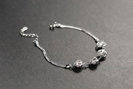 Lắc tay có chuông dạng dây mềm mại, với các mắt xích nhỏ và chuông xinh xắn, mang vẻ đẹp thanh lịch