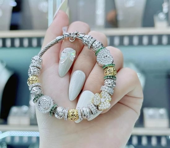 Lắc tay Pandora vàng trắng với charm trái tim ổ khóa và hoa ba cánh vàng đính hạt tinh xảo
