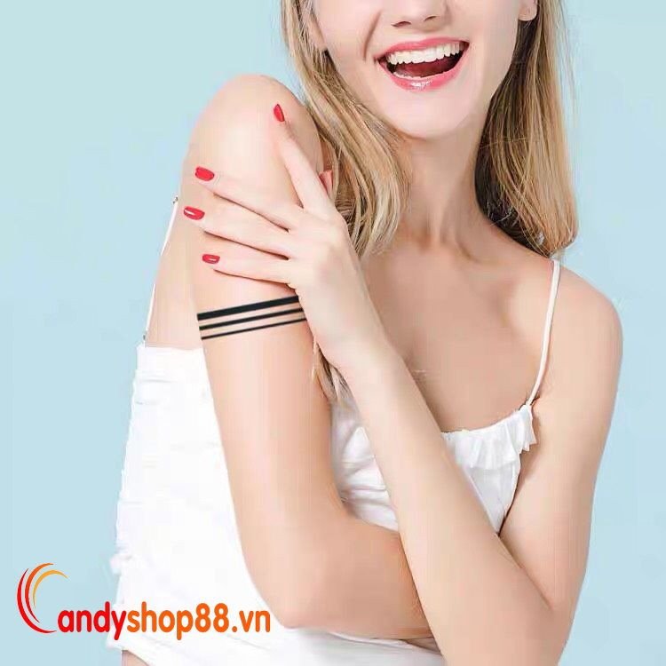 Một bàn tay đeo chiếc đồng hồ sang trọng cùng hình xăm vòng tay đen dán với thiết kế đơn giản, tạo điểm nhấn phong cách