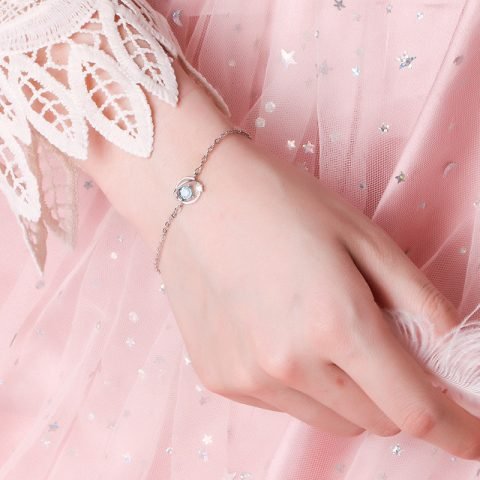 Một cô gái đeo lắc tay bạc tinh xảo ở cổ tay, minh họa việc con gái đeo lắc tay bên nào.