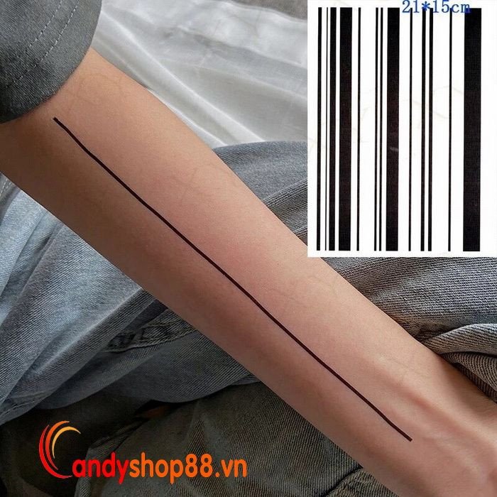 Một cô gái trẻ với nhiều hình xăm dán đường thẳng đen tạo thành các vòng trên cánh tay và cổ tay, thể hiện phong cách đường phố