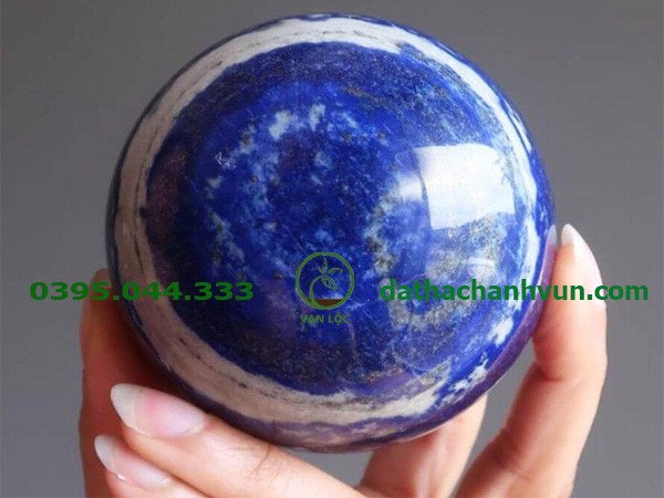 Một quả cầu đá thạch anh xanh nước biển lớn được đặt trên một đế gỗ, tỏa ra vẻ đẹp thanh thoát và mang lại nguồn năng lượng dồi dào cho không gian.