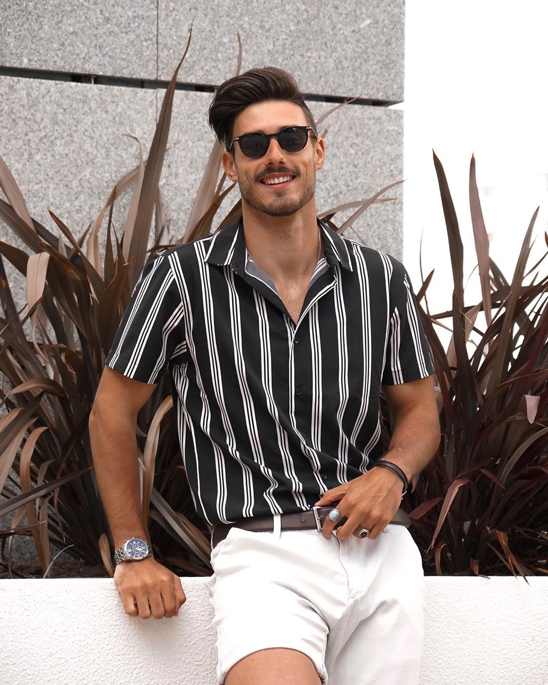 Người đàn ông với phong cách casual, đeo nhiều vòng tay chuỗi hạt và dây da, tạo điểm nhấn cá tính.