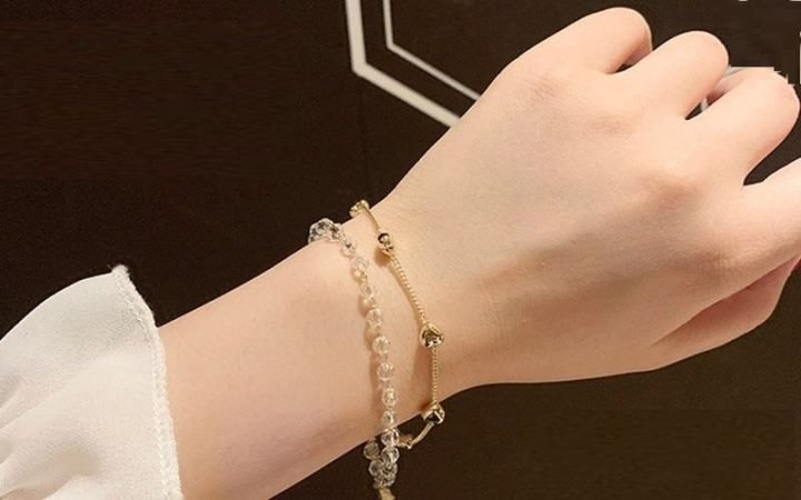 Người phụ nữ đeo chiếc lắc tay tinh xảo ở cổ tay trái, thể hiện sự may mắn và thanh lịch trong công việc