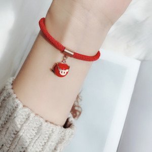Người phụ nữ đeo vòng tay chỉ đỏ trên cổ tay, thể hiện phong cách và niềm tin