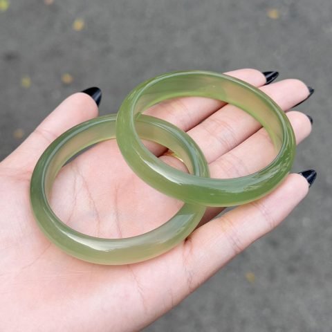 Vòng tay bản hẹ đá Bạch Nguyệt Quang với hiệu ứng ánh xanh, tôn lên vẻ thanh mảnh hiện đại.