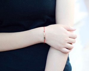 Vòng tay chỉ đỏ kết hợp với vật phẩm phong thủy mang ý nghĩa tâm linh