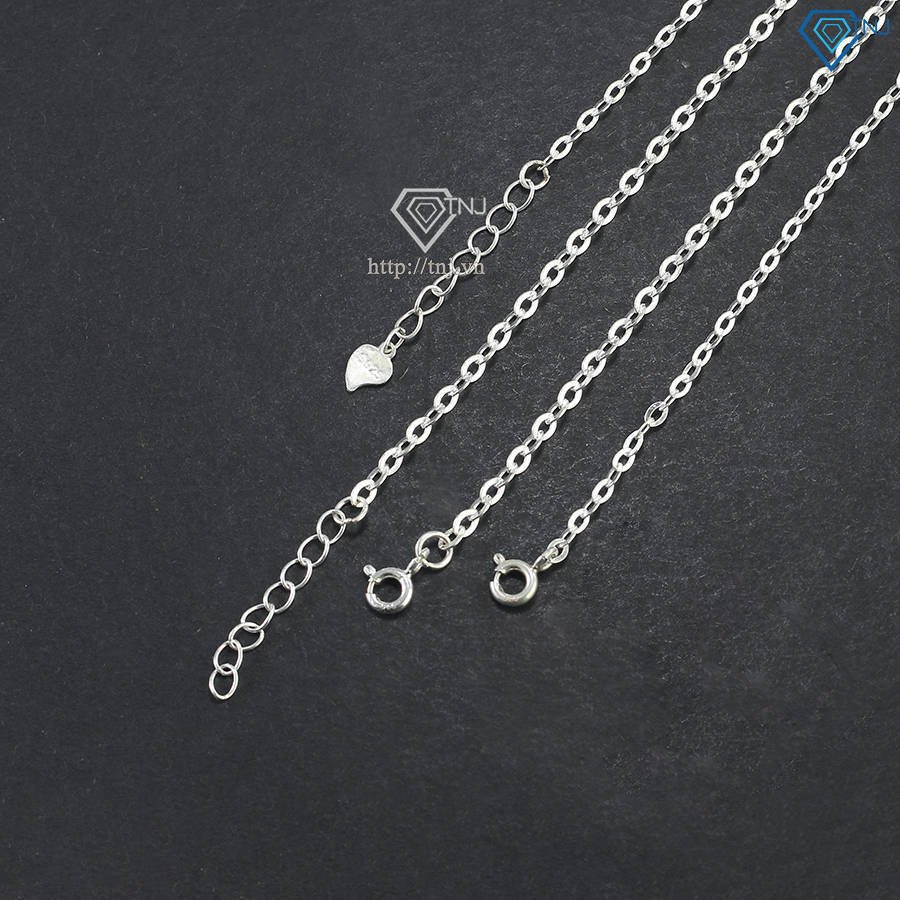 Vòng tay chữ cái bạc sáng bóng trên cổ tay, mang lại vẻ đẹp thanh lịch