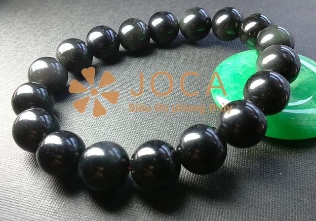 Vòng tay đá obsidian đen bóng tỏa sáng, thể hiện tác dụng phong thủy