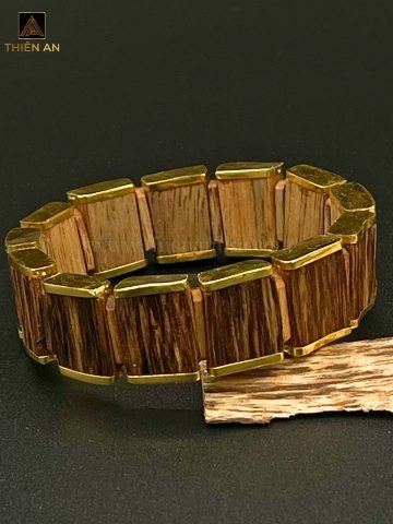 Vòng tay trầm bọc vàng 18K với thiết kế lắc bản tinh xảo, thể hiện vẻ đẹp sang trọng