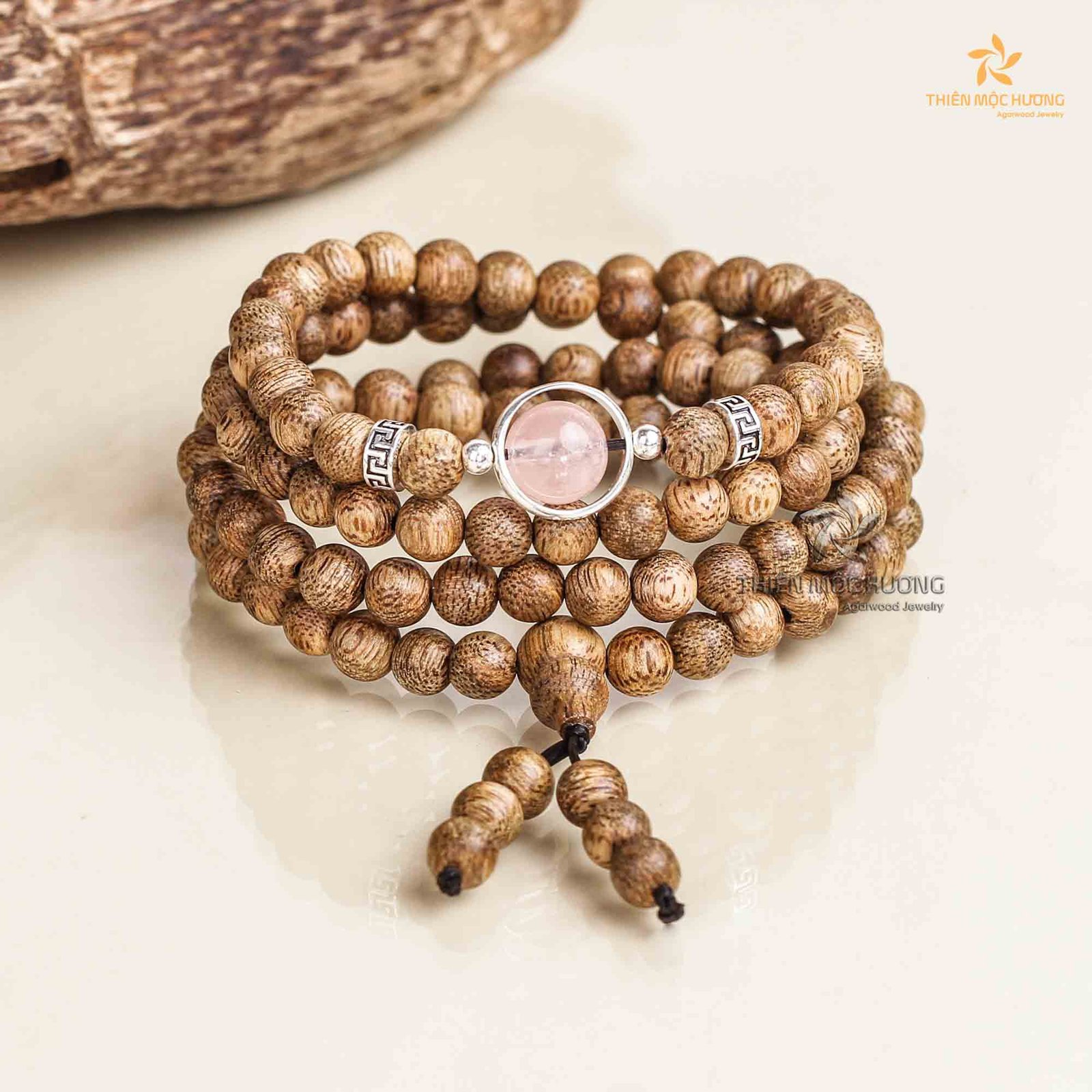 Vòng tay trầm hương với charm hồng, phù hợp cho mệnh Thổ
